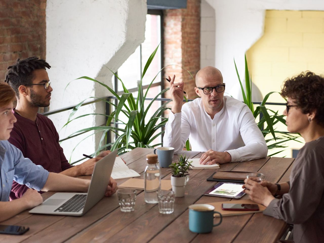 Colleagues talking around a table in a bright commercial workplace
