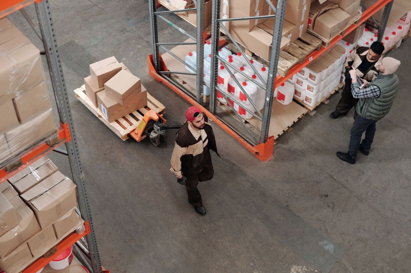 People walking between racking in a large warehouse during a site visit